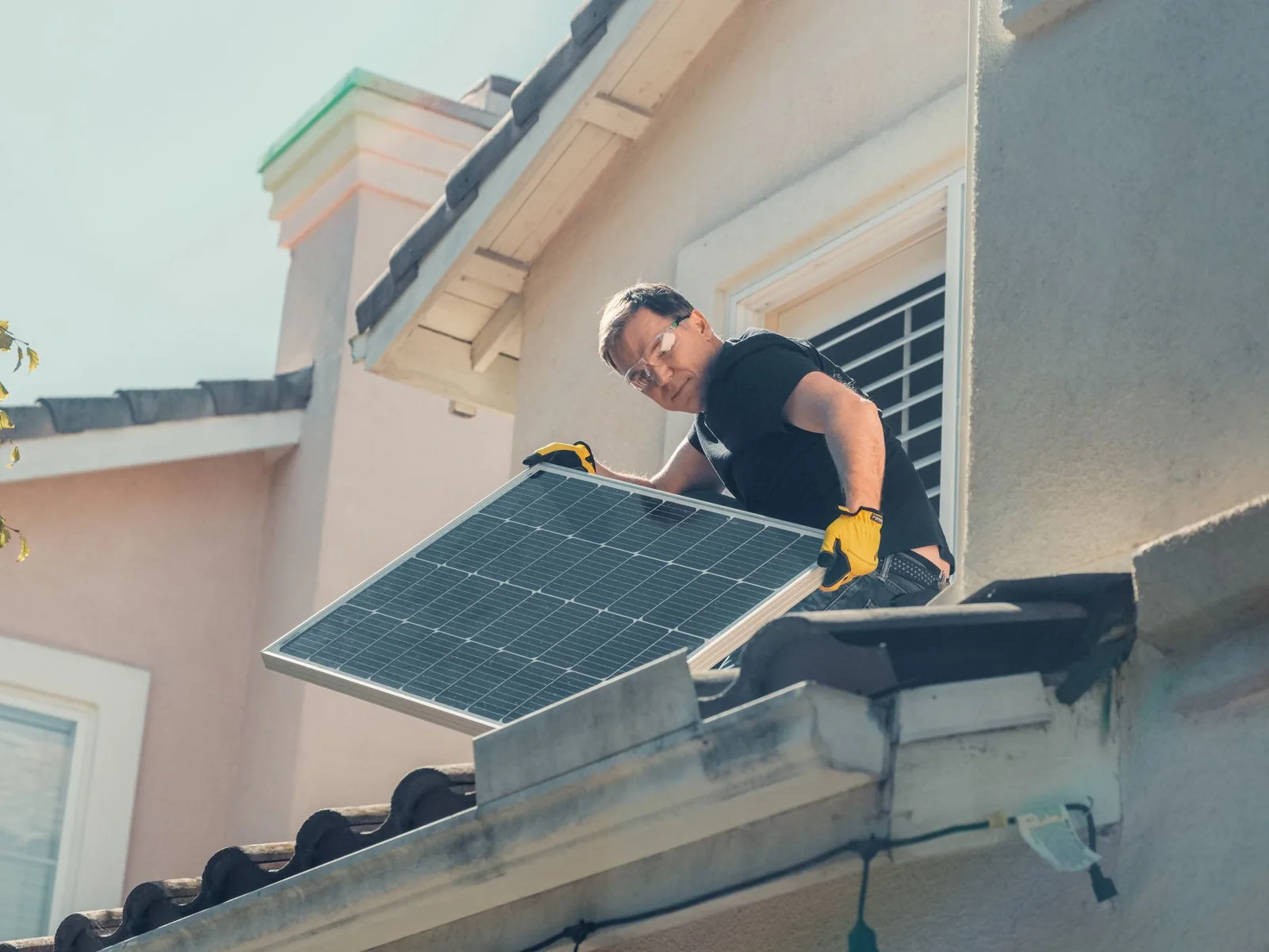 Monteur bij zonnepanelen op een pannendak, sfeerbeeld